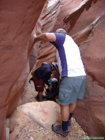 Chuck passing packs down a boulder choke in Wire Pass to Brian.